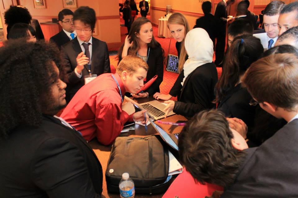 Marshal Digiovanna '16 (in red shirt) checks the progress of a working paper at the 2014 National Model UN conference in Washington DC, where he and his delegation partner, Thomas Winquist '15, won an award for an outstanding Position Paper.